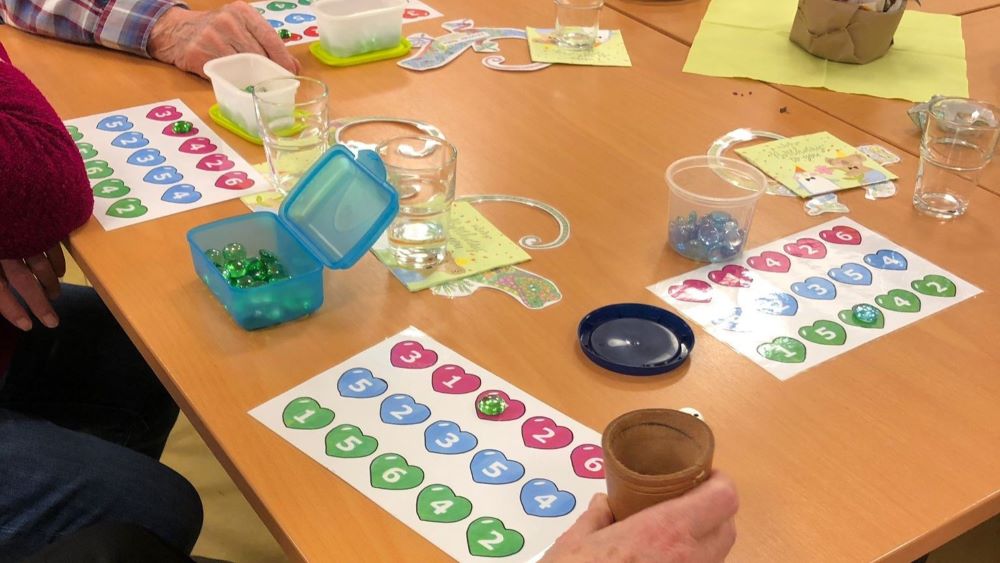 Herz-Würfelbingo fördert die Konzentration und die Motorik der Teilnehmenden in Carena-Gruppen. | Foto: Caritas