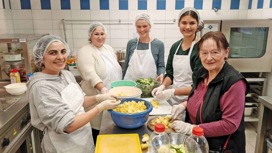 Das Foto zeigt eine Gruppe von Frauen, die Lebensmittel zubereiten.