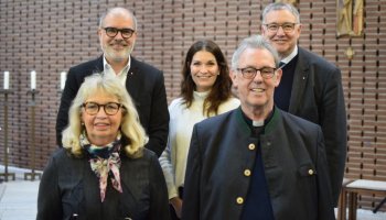 Auf Bild: fünf Personen stehen in zwei Reihen.