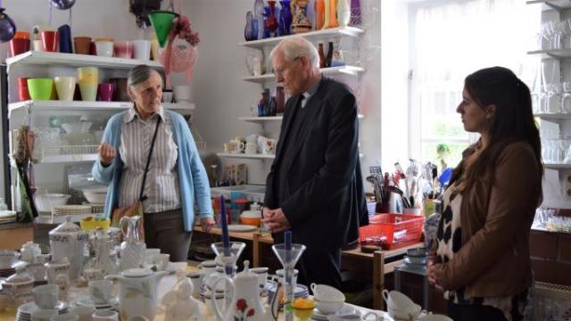 Gerdi Breuksch (l.) zeigt Weihbischof Dr. Nikolaus Schwerdtfeger das Angebot im FAIRKAUF-Laden der Caritas Südniedersachsen und berichtet über die Arbeit des Laden-Teams. | Foto: Johannes Broermann / cps