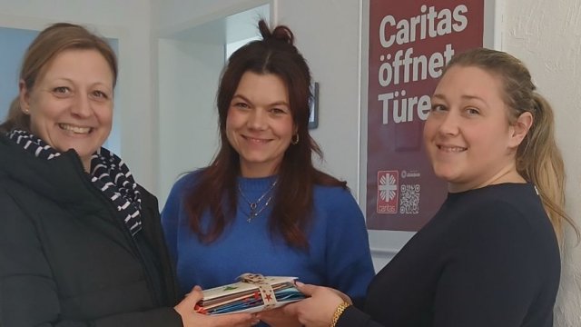 Das Foto zeigt drei Personen bei der Postübergabe.