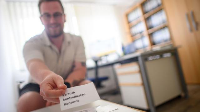 Jens Klie hält eine Karte mit der Aufschrift „Versuch, kontrollierten Konsums“. | Foto: Klaus-Dietmar Gabbert/dpa-tmn