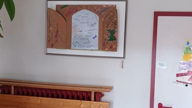 Kinder, Jugendliche und pädagogische Mitarbeitende bastelten eine Tür aus Pappe, in die das Foto des Eingangsbereichs geklebt wurde. | Foto: Caritas