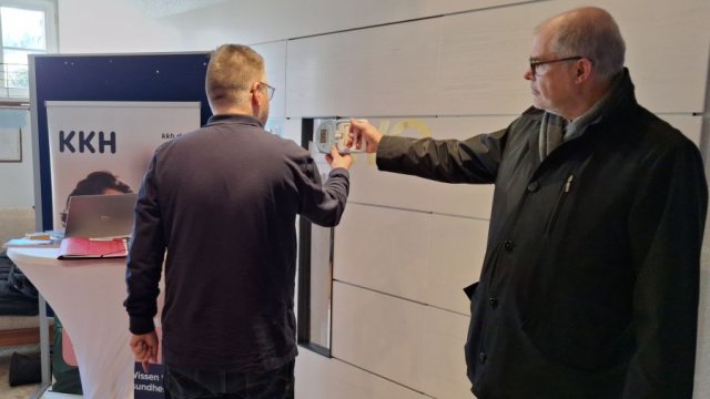 Das Foto zeigt Holger Gatzenmeyer wie er mit ausgestrecktem Arm das Handkraftmessgerät drückt.